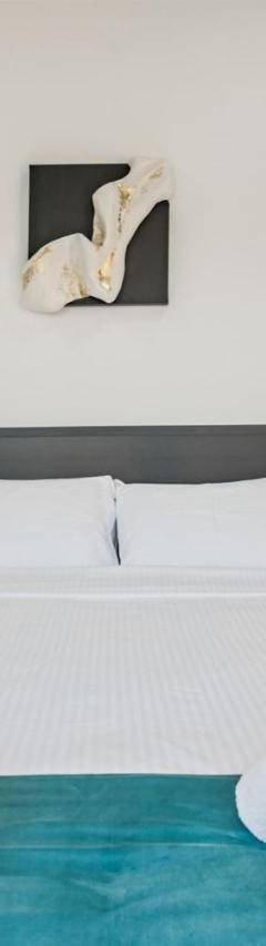 a bedroom with a large white bed with towels on it at Heart Of Nicosia - The Gem in Nicosia