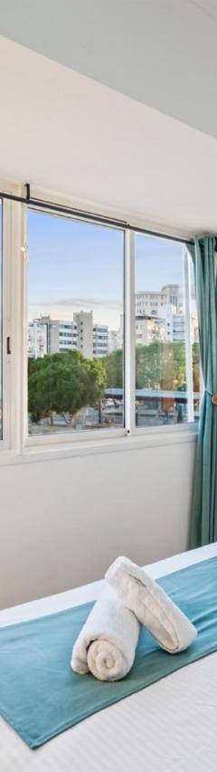 a bedroom with a bed and a large window at Heart Of Nicosia - The Gem in Nicosia