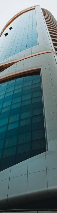 a tall glass office building with blue windows at The 1 -Nicosia Elite Stay- Gym Pool 24h Concierge in Nicosia