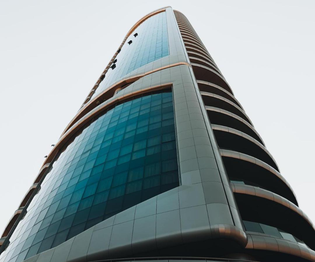 a tall glass office building with blue windows at The 1 -Nicosia Elite Stay- Gym Pool 24h Concierge in Nicosia