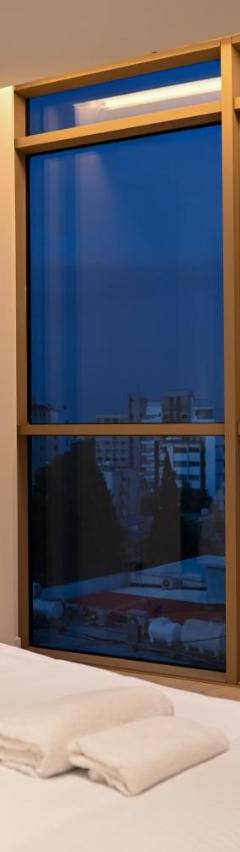 a bedroom with a bed and a large window at The 1 -Nicosia Elite Stay- Gym Pool 24h Concierge in Nicosia