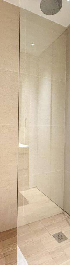 a shower with a glass door in a bathroom at The 1 -Nicosia Elite Stay- Gym Pool 24h Concierge in Nicosia
