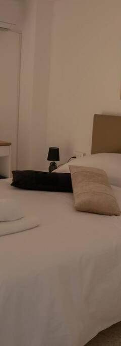 a bedroom with a white bed with two towels on it at Theo 202 - Cozy 2 Bdr Nicosia Free Parking &amp; Wi-Fi in Nicosia
