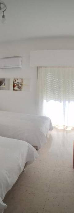 a hotel room with three beds and a window at Theo 202 - Cozy 2 Bdr Nicosia Free Parking &amp; Wi-Fi in Nicosia
