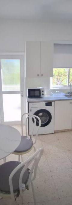 a kitchen with a table and chairs in a kitchen at Theo 202 - Cozy 2 Bdr Nicosia Free Parking &amp; Wi-Fi in Nicosia
