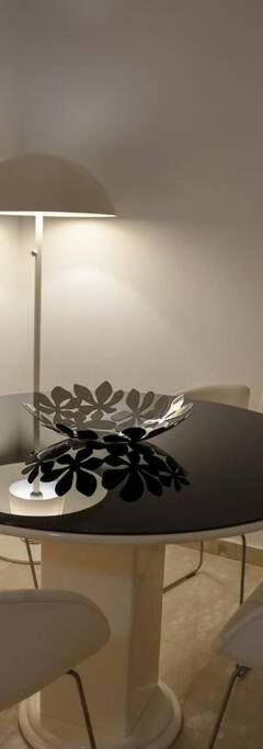 a dining room with a black table and white chairs at Theo 202 - Cozy 2 Bdr Nicosia Free Parking &amp; Wi-Fi in Nicosia