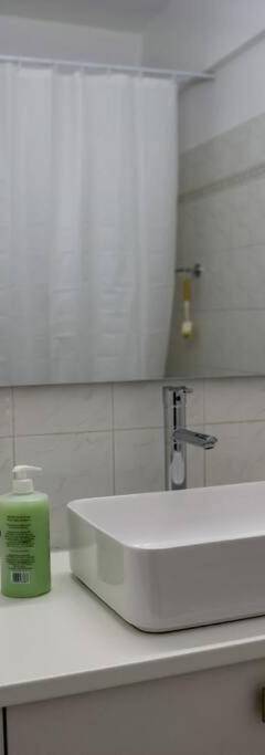 a bathroom with a white sink and a mirror at Theo 202 - Cozy 2 Bdr Nicosia Free Parking &amp; Wi-Fi in Nicosia