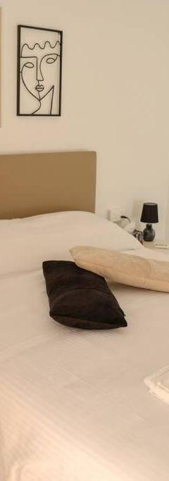 a bedroom with a white bed with towels on it at Theo 202 - Cozy 2 Bdr Nicosia Free Parking &amp; Wi-Fi in Nicosia