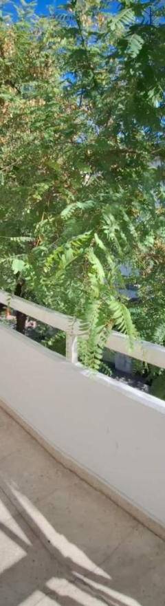 a balcony with two chairs and a large window at Theo 202 - Cozy 2 Bdr Nicosia Free Parking &amp; Wi-Fi in Nicosia