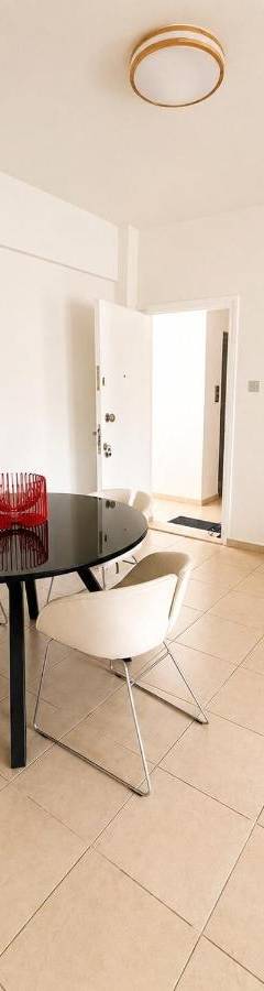 a dining room with a black table and white chairs at Theo 302 - Comfort 2 Queen Bdr Nicosia with Parking in Nicosia