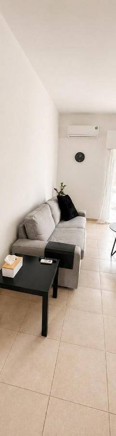 a living room with a couch and a mirror at Theo 302 - Comfort 2 Queen Bdr Nicosia with Parking in Nicosia