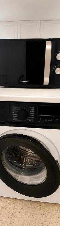 a microwave sitting on top of a washing machine at Theo 302 - Comfort 2 Queen Bdr Nicosia with Parking in Nicosia