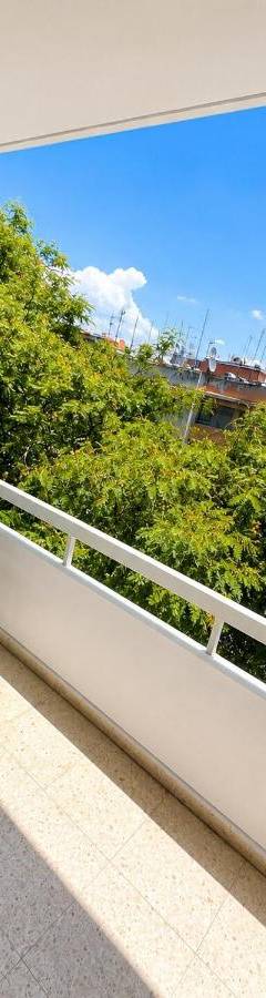 a chair on a balcony with a view of trees at Theo 302 - Comfort 2 Queen Bdr Nicosia with Parking in Nicosia