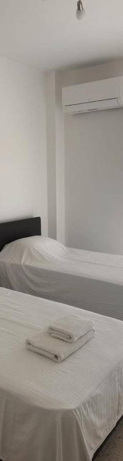 a room with two beds with white sheets and a window at Theo 403 - Charming 2 Bdr Nicosia, Parking &amp; Wi-Fi in Nicosia