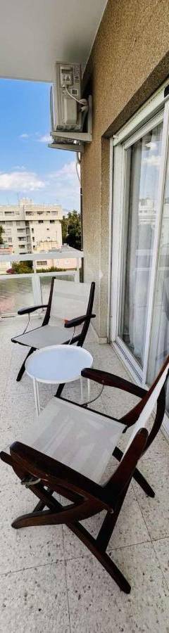 a balcony with chairs and a table on a building at Theo 403 - Charming 2 Bdr Nicosia, Parking &amp; Wi-Fi in Nicosia