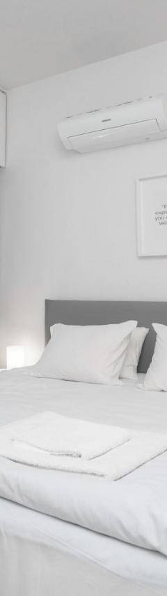 a white bedroom with a large bed with white sheets at Mayra Seafront Luxury Apartment (BREAKBOOKING-CY) in Limassol