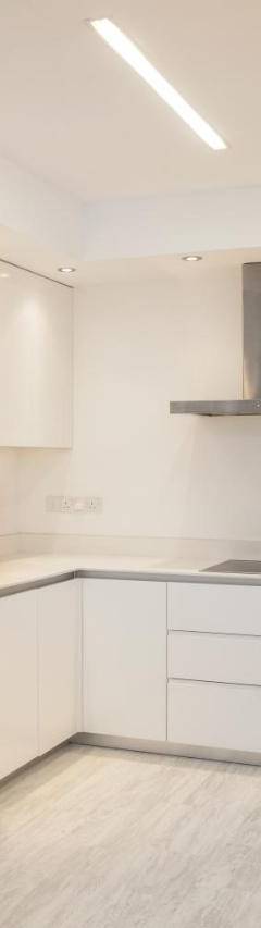 a kitchen with white cabinets and a stainless steel refrigerator at Mayra Seafront Luxury Apartment (BREAKBOOKING-CY) in Limassol