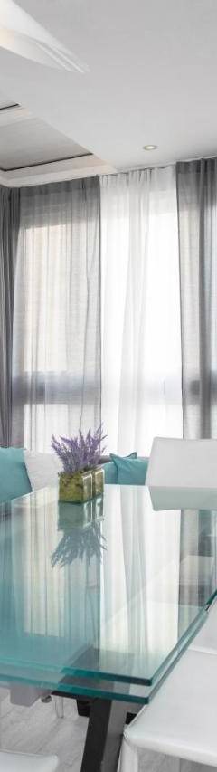 a dining room with a glass table and white chairs at Mayra Seafront Luxury Apartment (BREAKBOOKING-CY) in Limassol