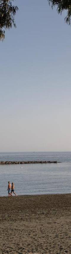 a person walking on a beach near the water at Mayra Seafront Luxury Apartment (BREAKBOOKING-CY) in Limassol