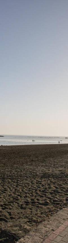 a brick path on a beach next to the water at Mayra Seafront Luxury Apartment (BREAKBOOKING-CY) in Limassol