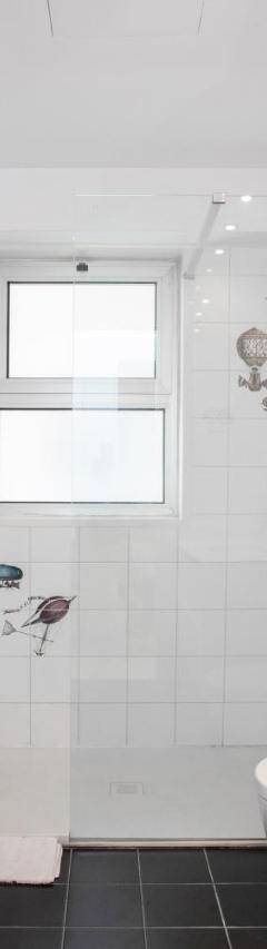 a white bathroom with a shower and a sink at Mayra Seafront Luxury Apartment (BREAKBOOKING-CY) in Limassol