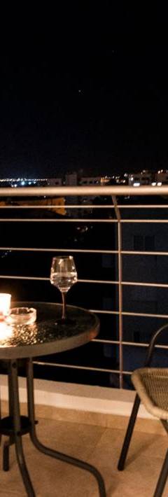 a table with two chairs and a candle on a balcony at Glabur Stays - The Sunny Atelier - Nicosia City, Free Parking &amp; Wifi, Welcomes You!!! in Nicosia