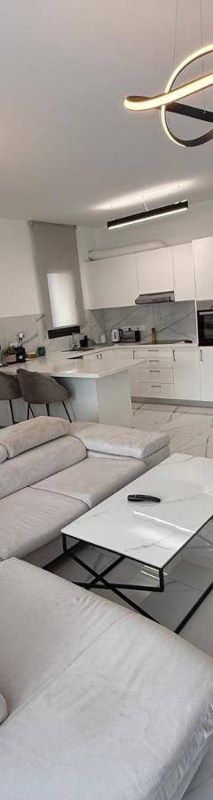 a living room with a white couch and a kitchen at Glabur Stays - Nicosia's Finest 2 Bedroom in Nicosia
