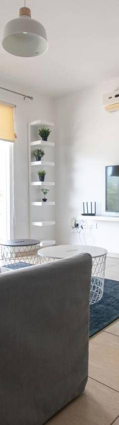 a living room with a gray couch and a tv at Glabur Stays - The Master Atelier - Nicosia City, Free Parking &amp; Wifi, Welcomes You!!! in Nicosia