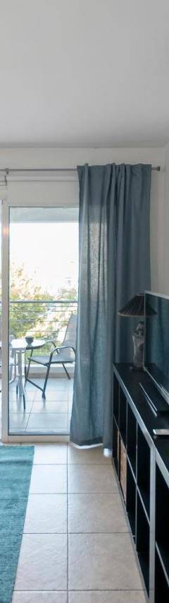 a living room with a blue couch and a clock on the wall at Glabur Stays - The Cozy Atelier - Nicosia City, Free Parking &amp; Wifi, Welcomes You!!! in Nicosia