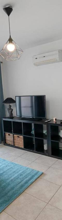 a living room with a blue couch and a clock on the wall at Glabur Stays - The Cozy Atelier - Nicosia City, Free Parking &amp; Wifi, Welcomes You!!! in Nicosia