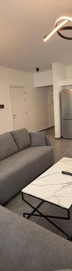 a living room with a couch and tables and a kitchen at Glabur Stays - Nicosia Elite 2BDR in Nicosia