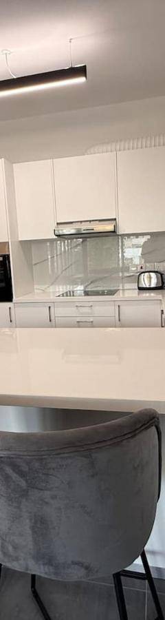 a kitchen with a white counter and two bar stools at Glabur Stays - Nicosia Elite 2BDR in Nicosia