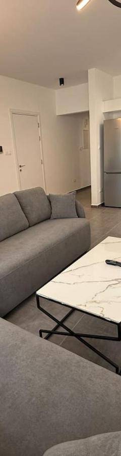 a living room with a couch and tables and a kitchen at Glabur Stays - Nicosia Elite 2BDR in Nicosia