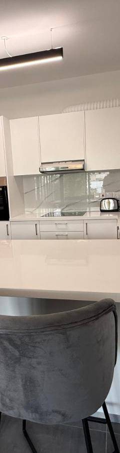 a kitchen with a white counter and two bar stools at Glabur Stays - Nicosia Elite 2BDR in Nicosia