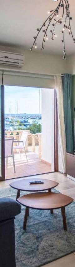 a living room with a blue couch and a large window at Glabur Stays! The One -1 - Elite Marina Front! in Zygi