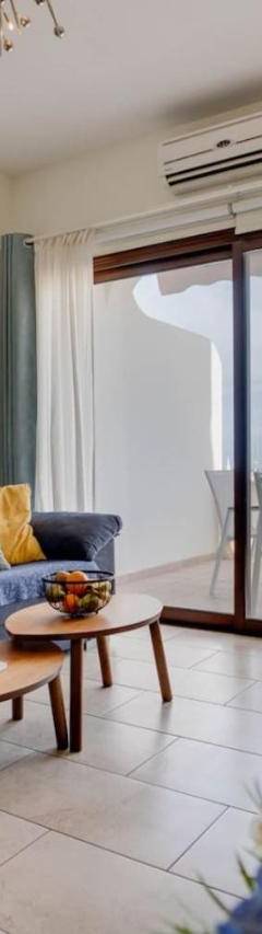 a living room with a blue couch and a table at Glabur Stays! The One -1 - Elite Marina Front! in Zygi