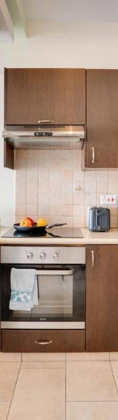 a kitchen with wooden cabinets and a refrigerator at Glabur Stays! The One -1 - Elite Marina Front! in Zygi