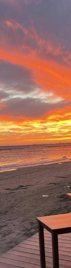 a person taking a picture of a sunset on the beach at Glabur Stays! The One -1 - Elite Marina Front! in Zygi