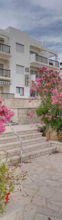 a white building with pink flowers in front of it at Glabur Stays! The One -1 - Elite Marina Front! in Zygi