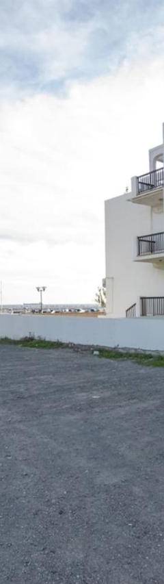 a white apartment building with a parking lot at Glabur Stays! The One -1 - Elite Marina Front! in Zygi