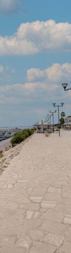 a sidewalk next to a harbor with boats in the water at Glabur Stays! The One -1 - Elite Marina Front! in Zygi
