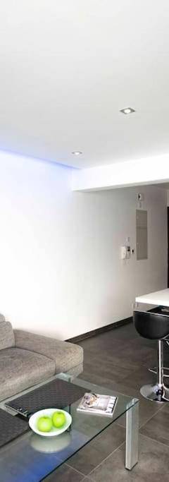 a living room with a couch and a kitchen at Glabur Stays - The Amazing 1 BDR - Executive apt Nicosia Center Free Parking &amp; WiFi in Nicosia