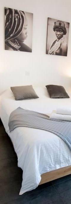 a white bedroom with a large bed and a chair at Glabur Stays - The Amazing 1 BDR - Executive apt Nicosia Center Free Parking &amp; WiFi in Nicosia