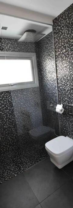 a bathroom with a toilet and a shower and a window at Glabur Stays - The Amazing 1 BDR - Executive apt Nicosia Center Free Parking &amp; WiFi in Nicosia