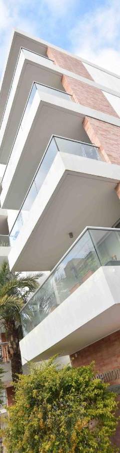 a large white building with palm trees in front of it at Glabur Stays - The Amazing 1 BDR - Executive apt Nicosia Center Free Parking &amp; WiFi in Nicosia