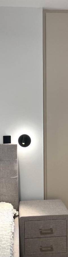a bedroom with a bed and a nightstand next to a door at Sweet Luxury 2BR Nicosia City in Nicosia