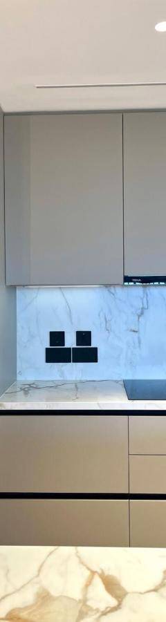 a kitchen with white cabinets and black appliances at Sweet Luxury 2BR Nicosia City in Nicosia