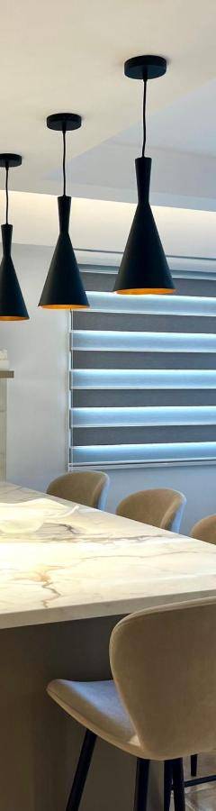 a kitchen with a island with chairs and pendant lights at Sweet Luxury 2BR Nicosia City in Nicosia