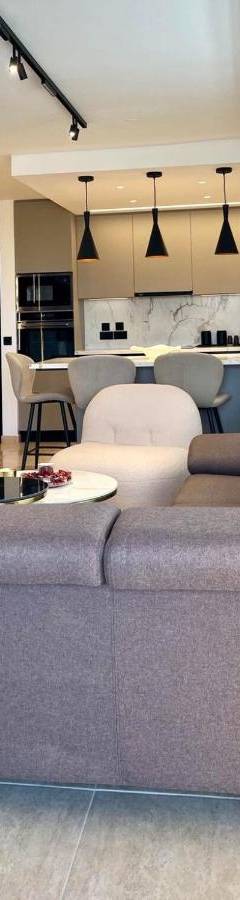 a living room with a large couch and a kitchen at Sweet Luxury 2BR Nicosia City in Nicosia