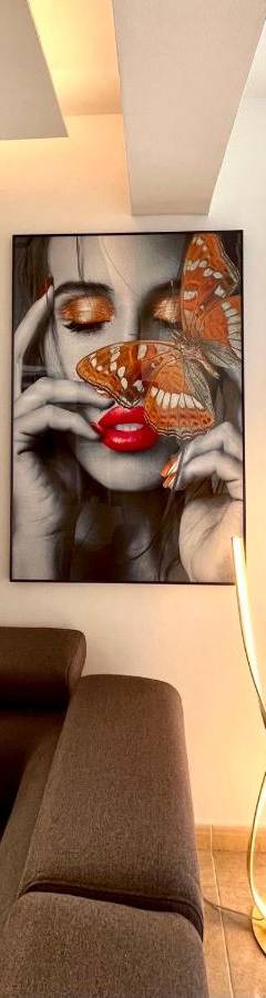 a living room with a painting of a woman holding a butterfly at Sweet Luxury 2BR Nicosia City in Nicosia